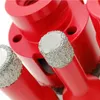 A close-up view of several red diamond drill bits with silver tips, set against a white background. Produktbild-Vorschau