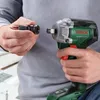 A person is holding a Bosch impact driver and a socket adapter, preparing to attach the adapter to the driver. Podgląd zdjęcia produktu
