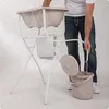 A person is using a baby bath tub with a stand and a bucket. Produktbild-Vorschau