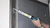 A person is using a caulking gun to apply sealant to a joint. Produktbild-Vorschau