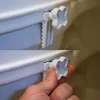 A close-up of a hand adjusting a white toilet seat riser attachment. Anteprima dell’immagine prodotto