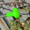 Close-up of a green shower head with water droplets on it, attached to a clear tube. Náhled obrázku produktu