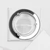 A close-up view of a white shower drain with a silver trim and screws, set against a textured white background. A white lid is partially visible in the lower right corner. Náhled obrázku produktu
