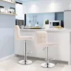 A modern kitchen with two cream-colored bar stools in the foreground. Produktbild-Vorschau