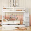 A white bunk bed with a pull-out trundle bed in a child's bedroom. Voir les images du produit