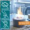 A tabletop bioethanol fireplace with decorative stones and flames, shown on a table with a lighter and a drink in the background. Informational graphics are on the left side. Produktbild-Vorschau