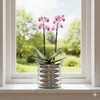 A potted orchid plant sits on a windowsill with a garden visible through the window. Produktbild-Vorschau