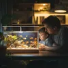 A father and son are looking at a fish tank. Podgląd zdjęcia produktu