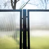 A close-up view of a black metal gate with clear polycarbonate panels. Voir les images du produit