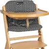 A close-up view of a wooden high chair with a geometric patterned seat cushion and tray. Produktbild-Vorschau