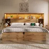 A bedroom scene featuring a large bed with a headboard that has integrated shelving and lighting. Náhled obrázku produktu