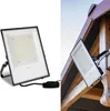 A split image showing a product shot of an LED floodlight on the left and the same floodlight installed on a wooden structure on the right. Voir les images du produit