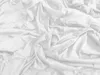 A close-up, top-down view of a crumpled white bedsheet. Podgląd zdjęcia produktu