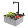 A modern stainless steel kitchen sink with a black faucet, filled with fresh vegetables and tomatoes. Water is running from the faucet. Náhled obrázku produktu