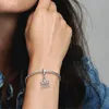 A person's wrist wearing a silver charm bracelet with a Brandenburg Gate charm. Produktbild-Vorschau