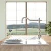 A kitchen faucet is shown in front of a large window with a view of a landscape. Produktbild-Vorschau