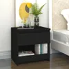 A black nightstand next to a bed, with artwork and a plant on top. Náhľad obrázku produktu