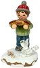 Ein kleines Kind in Winterkleidung hält eine lange Wurst in den Händen während eine Katze und eine Spielzeugmaus auf einem schneebedeckten Sockel daneben sitzen Produktbild-Vorschau