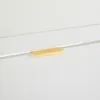A close-up view of a white cabinet with a gold handle. Produktbild-Vorschau