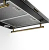 A close-up, angled view of the underside of a black kitchen range hood with gold accents. Podgląd zdjęcia produktu