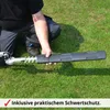 A person is holding a hedge trimmer attachment with a protective cover on it, on a grassy lawn. Produktbild-Vorschau