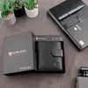 A black leather wallet is presented in its packaging, alongside a notebook and pen, and decorative plants. Produktbild-Vorschau