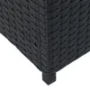 A close-up view of the corner and leg of a black rattan storage bench. Produktbild-Vorschau