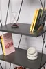 A close-up of a shelf in a bookshelf, displaying books, an hourglass, and a candle holder. Náhled obrázku produktu