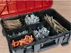 A red and black toolbox filled with various screws, bolts, and wall plugs. Anteprima dell’immagine prodotto