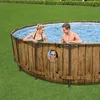 A family enjoys a round above-ground swimming pool in a grassy backyard. Produktbild-Vorschau