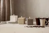 Three bubble cube candles with lit wicks, coffee beans, and mugs on a wooden table. Podgląd zdjęcia produktu