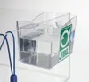 A clear plastic fish catching cup with a green JBL logo attached to the side, filled with water and attached to the side of an aquarium. Produktbild-Vorschau