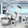 A multi-functional kitchen appliance, a stand mixer with attachments for a meat grinder and blender, is displayed on a countertop in a kitchen setting. A close-up inset shows a control panel. Produktbild-Vorschau