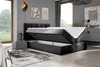 A modern bedroom with a black boxspring bed with the storage compartments open, a nightstand, and abstract art on the wall. Produktbild-Vorschau