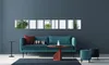 A modern living room with a teal sofa, a red coffee table, and decorative mirrors on the wall. Produktbild-Vorschau