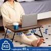 A person sitting on the floor with a laptop on a portable table and a cup of coffee. Produktbild-Vorschau