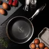A frying pan is shown on a black surface with eggs and herbs. Náhľad obrázku produktu