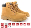 A pair of beige-brown suede work boots with black accents, displayed against a white background. Below the boots are several certification and safety icons. Produktbild-Vorschau