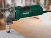 A green and gray electric tool is shown on a light-colored surface. Podgląd zdjęcia produktu
