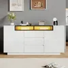 A white and black sideboard with yellow LED lighting is displayed in a room with two framed pictures on the wall. Produktbild-Vorschau