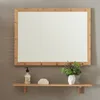 A mirror with a shelf mounted on a wall. Produktbild-Vorschau