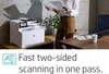 A woman is holding papers next to an HP printer in an office setting. Podgląd zdjęcia produktu