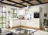 A modern, white L-shaped kitchen with wooden accents and a large window overlooking a garden.