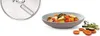 A close-up of a food processor blade and a bowl of chopped vegetables. Produktbild-Vorschau