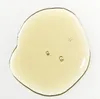 A close-up of a drop of clear, yellow liquid with small bubbles. Podgląd zdjęcia produktu