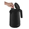 A hand is shown opening the lid of a black electric kettle. Náhled obrázku produktu