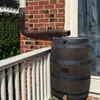 A rain barrel connected to a downspout on a deck next to a brick house. Náhled obrázku produktu