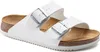 A pair of white Birkenstock Arizona sandals shown from a side angle on a white background. Náhľad obrázku produktu