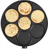 A top-down view of a crêpe maker with several crêpes being cooked. Voir les images du produit