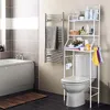 A bathroom scene with a toilet and an over-the-toilet storage rack. A towel rack with a towel is on the wall. Podgląd zdjęcia produktu